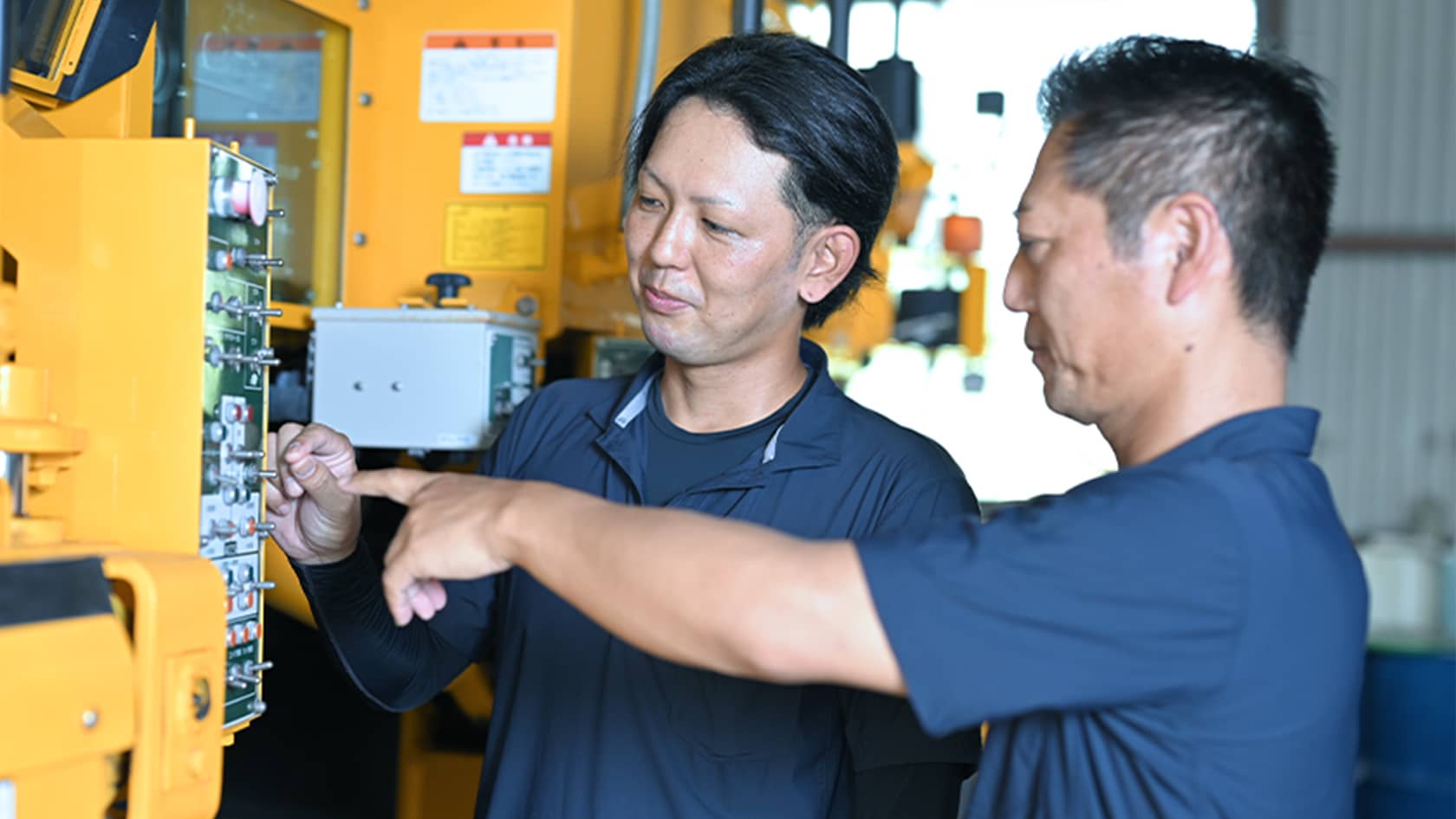 先輩社員が後輩社員に作業手順を教えている様子